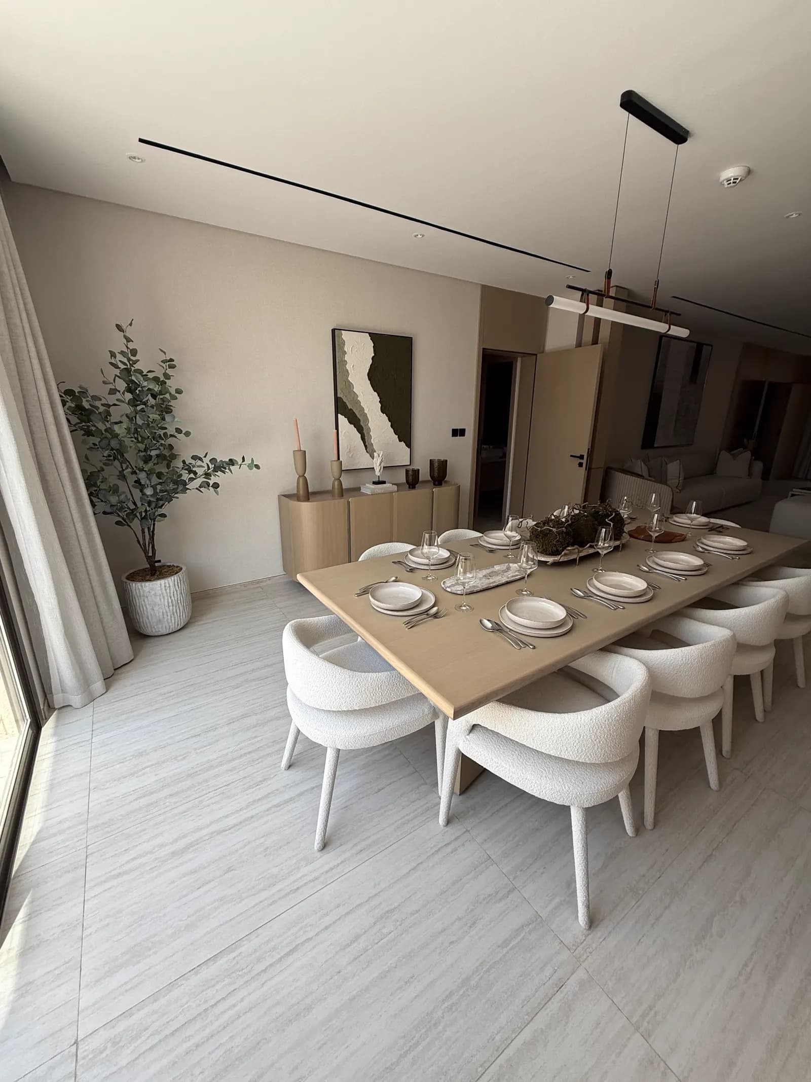 Dining area with sculptural centrepiece, upholstered chairs and timber joinery