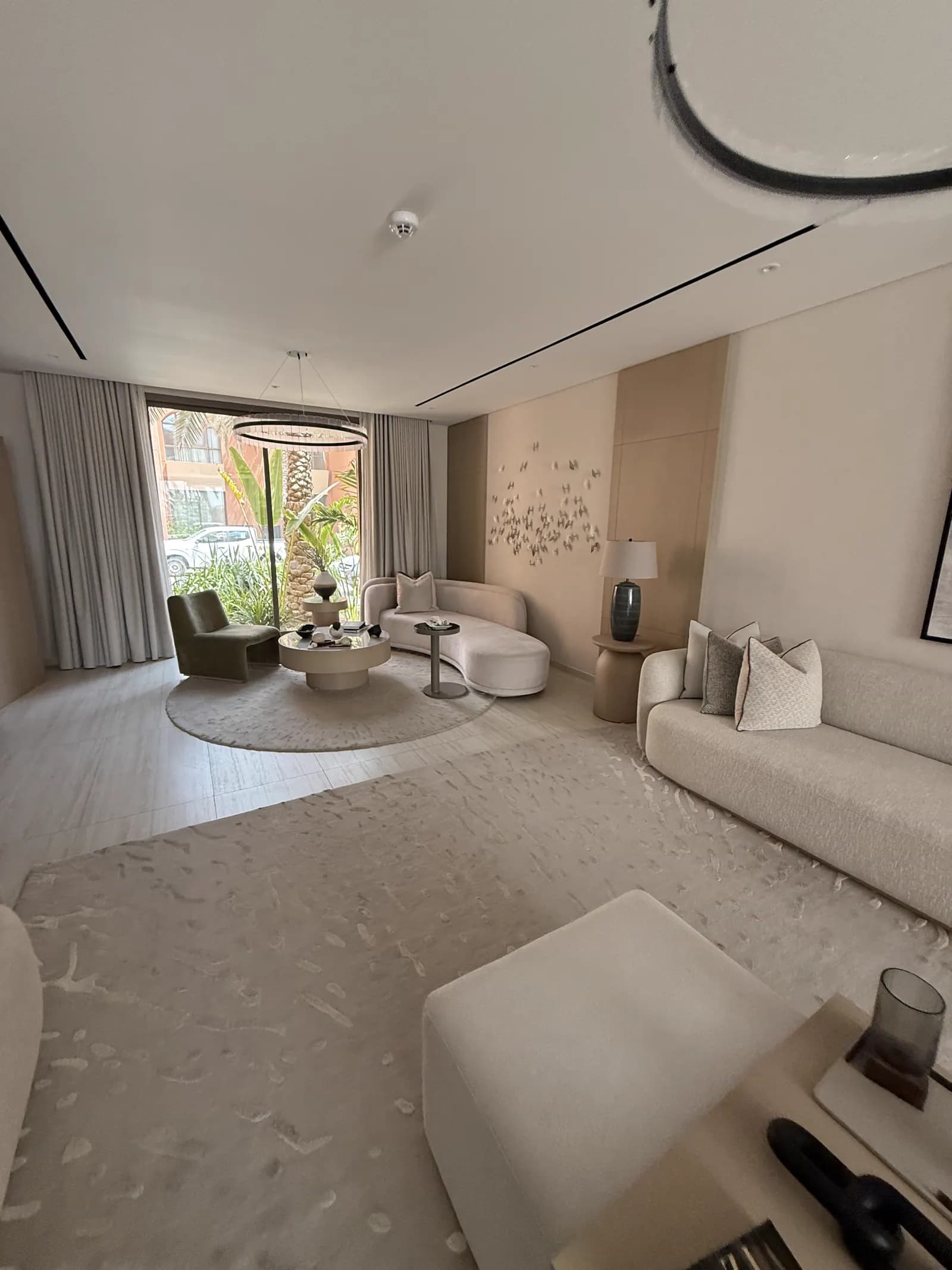 Reception room with rounded seating, layered curtains and a circular rug