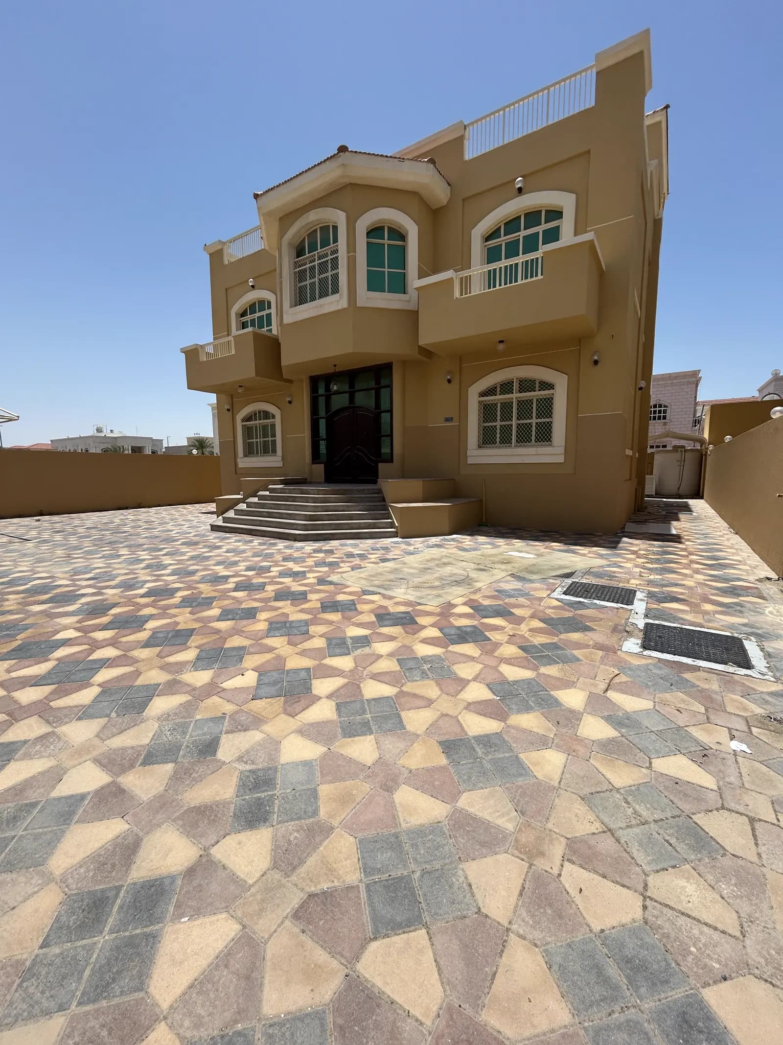 Villa entrance approached by a driveway laid in patterned interlocking paving