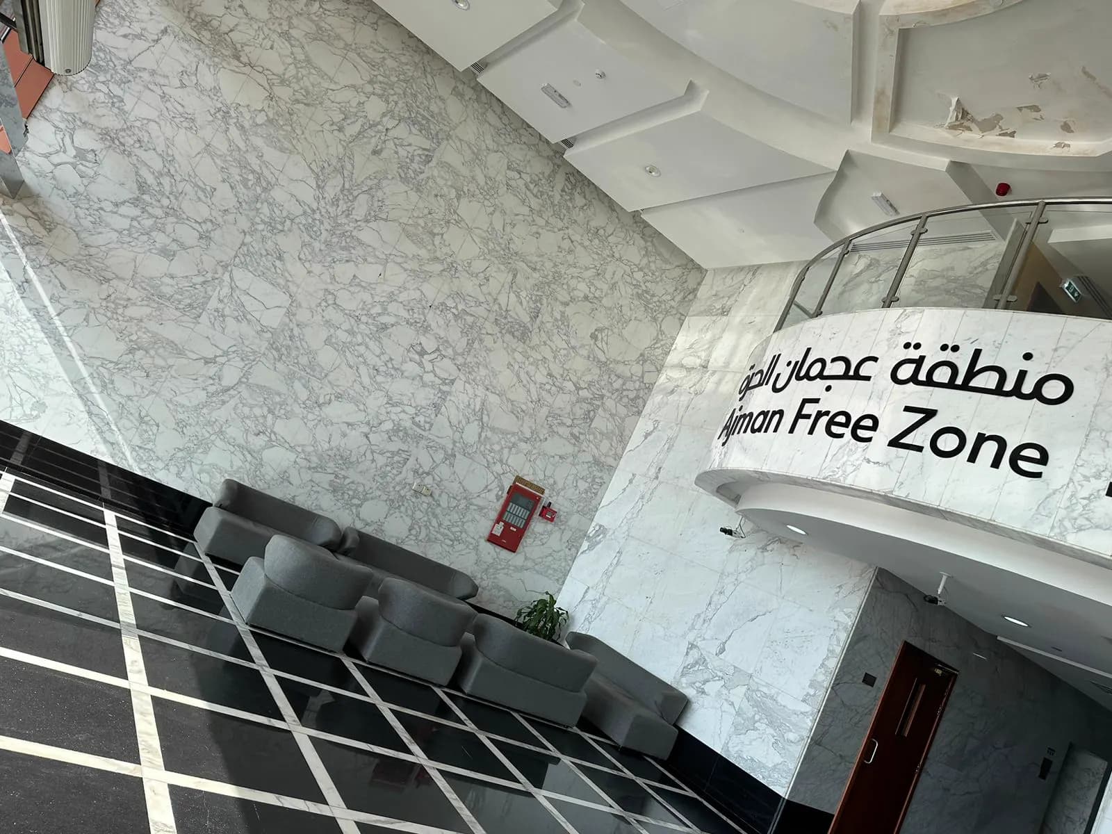 Marble-clad reception lobby with waiting seating at the Ajman Free Zone offices